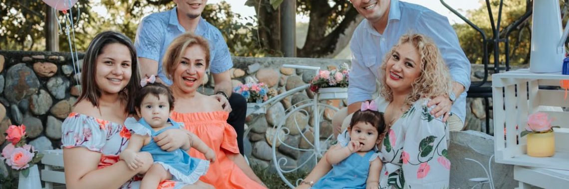 A joyful family enjoying an outdoor gathering in La Dorada, Colombia, surrounded by colorful decor.